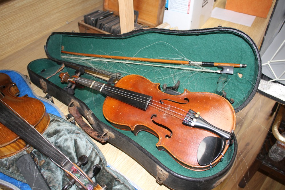 A violin with two piece back and bow, and a childs violin with bow, both with cases